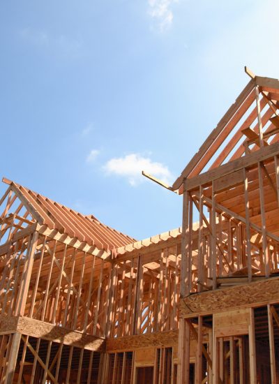 Wooden frame of a new house under construction against a bright sunny sky
